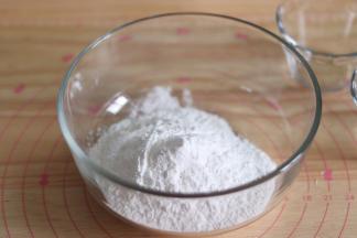 1、提前准备好豆沙馅，并做成小圆球冻硬。水磨糯米粉放到容器中。