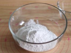 1、提前准备好豆沙馅，并做成小圆球冻硬。水磨糯米粉放到容器中。