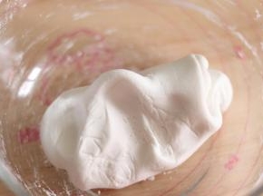 4、戴好防粘手套，把糯米和成一个光滑的团，软硬程度，类似于耳垂，而且不粘容器底。