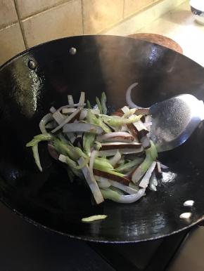 锅中余油爆香芹菜香干放入洋葱炒熟