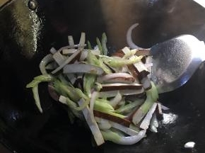锅中余油爆香芹菜香干放入洋葱炒熟