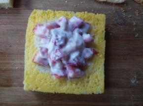 将混合好的草莓酸奶放在吐司上，将吐司的边缘刷上蛋液。