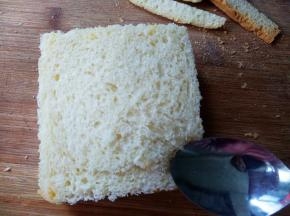 另一片吐司盖在上面，拿勺子将吐司边缘压紧。