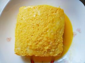 放入装有鸡蛋液的盘中，将吐司上下四周刷上鸡蛋液。