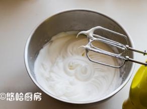 用打蛋器2档继续搅打1分钟，换1档继续搅打，一直打至抬起打蛋头能拉起小弯钩为止。