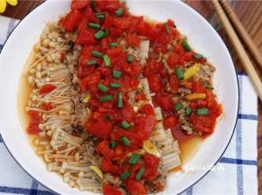 将番茄浇在金针菇上，撒上葱花。