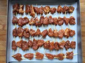 将肉一个一个串上放入烤盘，