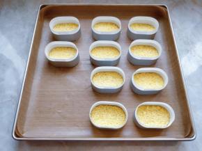 用椭圆形慕斯模刻出形状后，在椭圆模中铺好条状油纸，把蛋糕片放在底部，放在一边备用（椭圆模和配套的条状油纸在淘宝就能买到）。