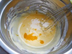 将奶油芝士和牛奶倒入小锅中，小火融化搅打至顺滑无颗粒，加入隔水融化的黄油，拌匀后逐个加入蛋黄，混合均匀。