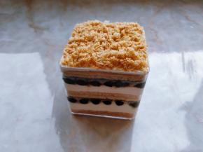 22. 以此类推，把第三层蛋糕片放好，表面涂少许奶茶奶油抹平。再将切蛋糕片时的边角料用筛网或擦丝器刨出蛋糕屑，洒在上面即可。