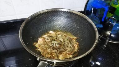 锅里放入宽油烧开，倒入河虾炸出水份