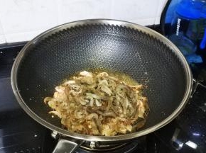 锅里放入宽油烧开，倒入河虾炸出水份
