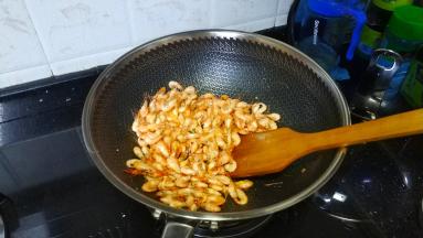 锅里继续热油倒入河虾炒至酥脆