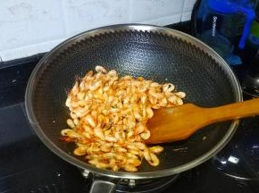 锅里继续热油倒入河虾炒至酥脆