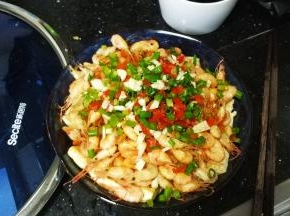 将锅里将葱、蒜、青红椒碎放入虾顶部