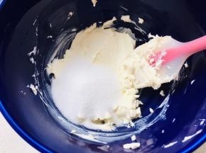 4、奶油奶酪室温软化，用刮刀按压成膏状后，加入白砂糖打至顺滑