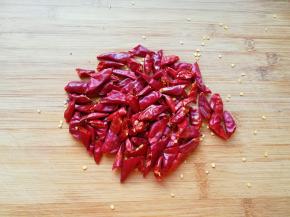 干红辣椒用剪刀剪开成两半。