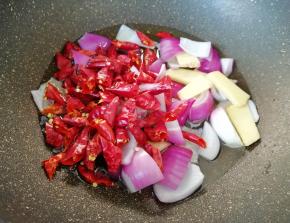 下入洋葱、生姜和干红辣椒中小火炸制。