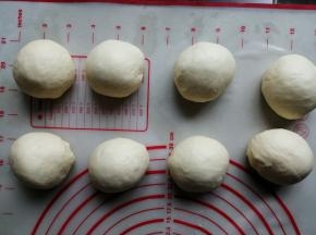 将面团取出，轻压排气，分成8份，滚圆后盖上保鲜膜，松驰20分钟
