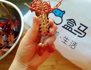 断生的小龙虾捞出晾一下，捏着小龙虾的尾巴最后一节，左右拧一下抽出虾线，如图。