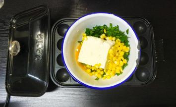 将玉米粒、豆腐、鸡蛋、菜心碎放入盆里