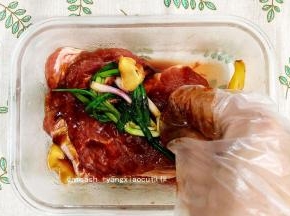 用手抓拌，让肉均匀地沾到酱汁，把姜片和葱结一起放入保鲜盒中，搓一搓，以使入味