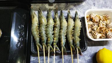 竹签从虾尾串到头，防止虾在盐焗时卷起，竹签过长可剪短到虾尾的长度
