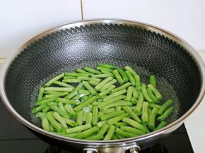 将处理好的刀豆焯水，锅中加入水烧开，滴两滴食用油，下刀豆，大火煮2分钟，捞出过冷水