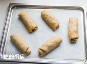 面团自上而下卷起卷紧，收口捏紧后摆放在烤盘上。烤盘放入烤箱中（不插电），下面放一碗热水进行二次发酵。