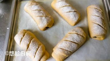 一个小时候后面团发酵到位，面团表面撒干粉、划刀口，放入已提前预热180度的烤箱下层，烘烤35分钟，那碗热水继续放在烤箱中不用取出。我用的烤箱是嵌入式蒸烤一体，下加热管从外面是看不到的，所以烘烤的时候烤盘都放在下层。