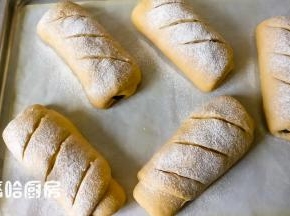 一个小时候后面团发酵到位，面团表面撒干粉、划刀口，放入已提前预热180度的烤箱下层，烘烤35分钟，那碗热水继续放在烤箱中不用取出。我用的烤箱是嵌入式蒸烤一体，下加热管从外面是看不到的，所以烘烤的时候烤盘都放在下层。