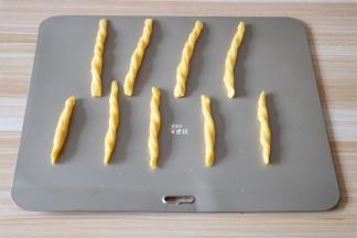 捏住长条的两端反方向扭几下，放在烤盘上；