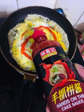 再翻过来，挤上手抓饼酱。