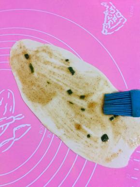 醒好的面团擀开，刷上油酥。