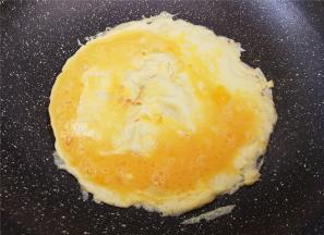 把鸡蛋磕入碗中均匀打散，起油锅，放入切碎蒜瓣爆香，再把蛋液倒入翻炒。