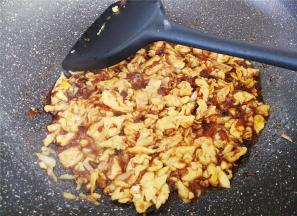 这时拿一个碗，放入1勺生抽，半勺老抽，2清水混合均匀倒入锅中鸡蛋里翻炒收汁。