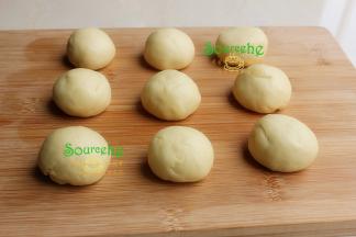 将发酵好的面团，用手排出空气，放在案板上压平，用擀面杖擀开，使面团里的气体尽量都被压出。把排完气的面团分成9分，每一份都揉圆.