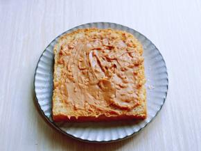 取一片吐司，涂抹上花生酱。(也可以换为你自己喜欢的酱料)