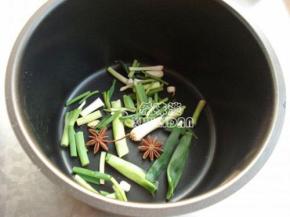 做把子肉选用砂锅，不过也可用电饭煲的，先铺入葱姜，八桂，桂皮在锅底。