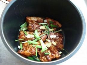 再放一层肉，将腌制肉片剩下的酱汁倒入锅里，把葱姜也放入肉片上。