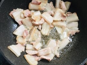  锅烧热倒入少许的油，放入五花肉煸炒出油脂来。