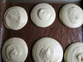 装入裱花袋中，挤入铺了油布或者油纸的烤盘上，一共挤了6个圆形，用勺子抹平表面