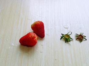 首先将草莓去蒂，依次做完。