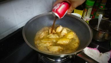 将可乐倒入煎好的鸡翅里