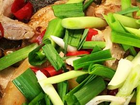 下入姜片、红辣椒、青蒜一同翻炒至青蒜断生。