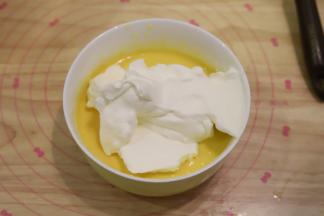 在芒果泥内加入五分之三的淡奶油，拌匀过筛。