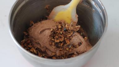 8.	核桃仁提前用烤箱180℃烘烤5分钟左右，核桃仁外皮金黄，取出切碎后加入基础面糊，翻拌均匀后装入裱花袋备用（预留几个比较完整的核桃仁最后做表面装饰用）