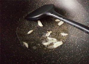 先热锅倒入食用油，升温后把蒜瓣洗净切片放入爆香。