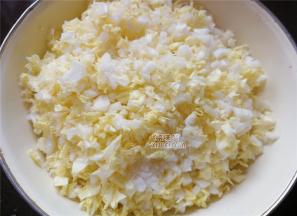 首先把白菜叶扳下，菜帮子切细丁，菜叶切细碎，装入盆中倒入适量的盐拌匀。