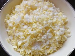 首先把白菜叶扳下，菜帮子切细丁，菜叶切细碎，装入盆中倒入适量的盐拌匀。